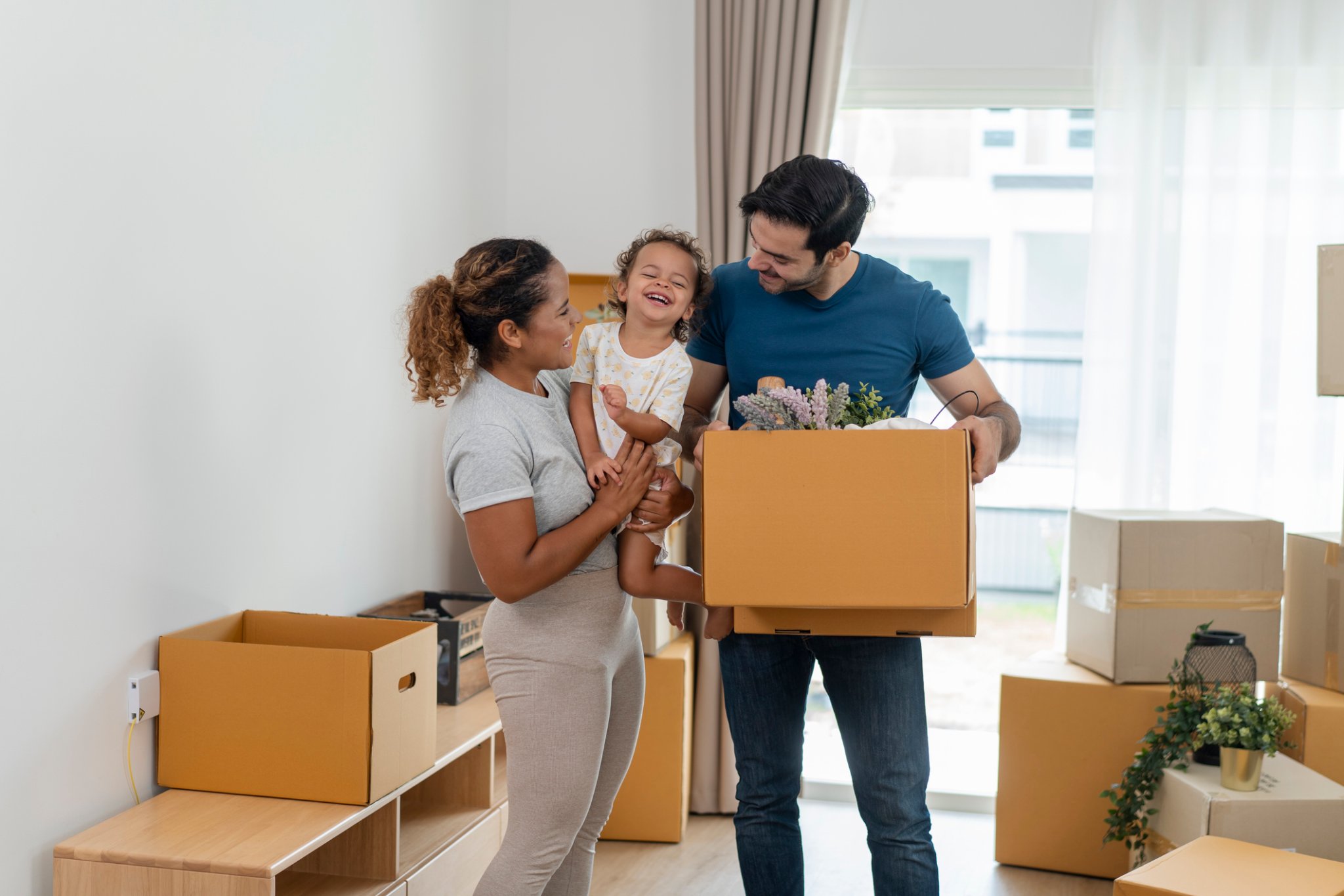 Young family with a toddler girl moving in new home.