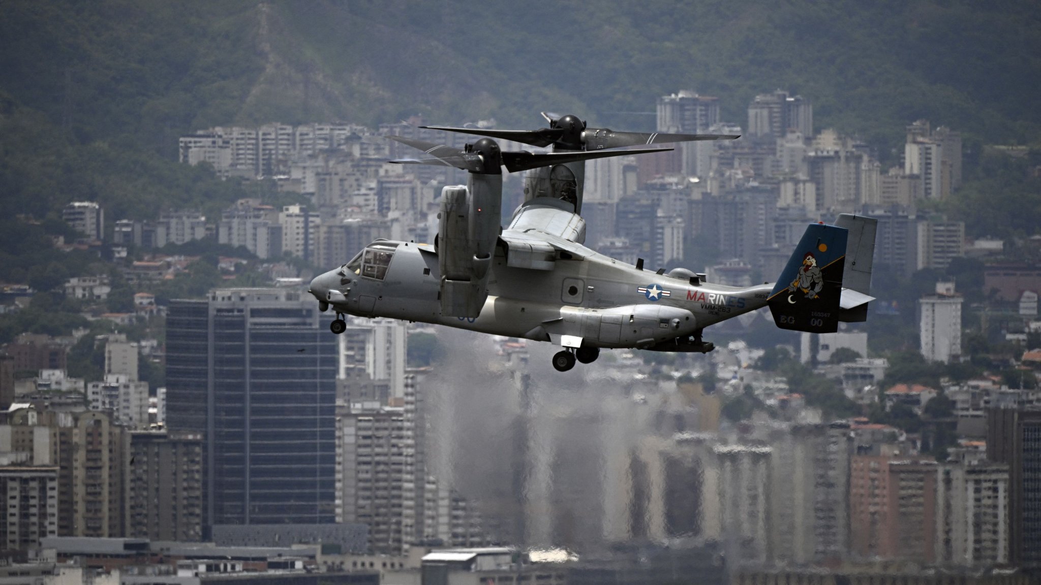 A US Marines MV-22B Osprey aircraft flies over the city on its way to the US Embassy, in Caracas, on May 23, 2026, during an air evacuation drill. (Photo by Federico PARRA / AFP via Getty Images)