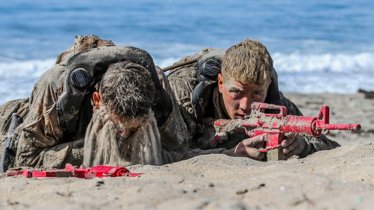 U.S. Marines with Basic Reconnaissance Course cover each other with sand for camouflage during clandestine landing and withdraw training at Naval Amphibious Base Coronado, California, Oct. 30, 2019. BRC is one of the many courses taught by the staff at Reconnaissance Training Company, Advanced Infantry Training Battalion, School of Infantry - West. The course provides students with the basic knowledge of reconnaissance doctrine, concepts, and techniques with emphasis on amphibious entry and extraction, beach reconnaissance and reconnaissance patrolling skills. (Marine Corps photo by Lance Cpl. Andrew Cortez)