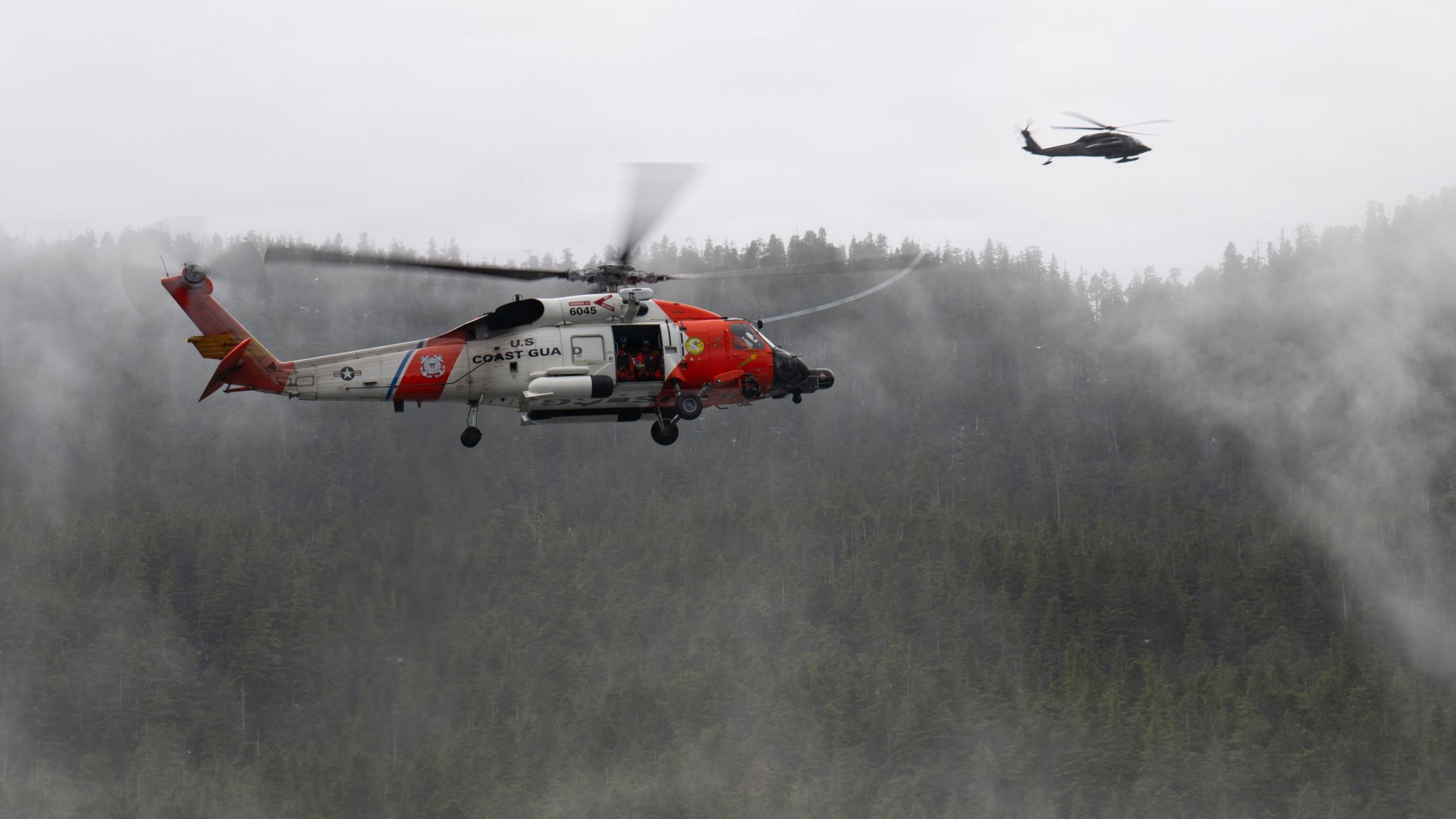 Image: A U.S. Coast Guard MH-60 Jayhawk helicopter crew with Air Station Sitka and A U.S. Army National Guard UH-60L Black Hawk helicopter crew from Juneau, Alaska, fly near each other during a mass casualty exercise near Sitka, Alaska, April 16, 2026. The helicopter crews rescued a large number of training participants that simulated distress in difficult to navigate areas during a large joint exercise involving multiple government agencies and local organizations. (U.S. Coast Guard photo by Petty Officer 2nd Class John Hightower) 