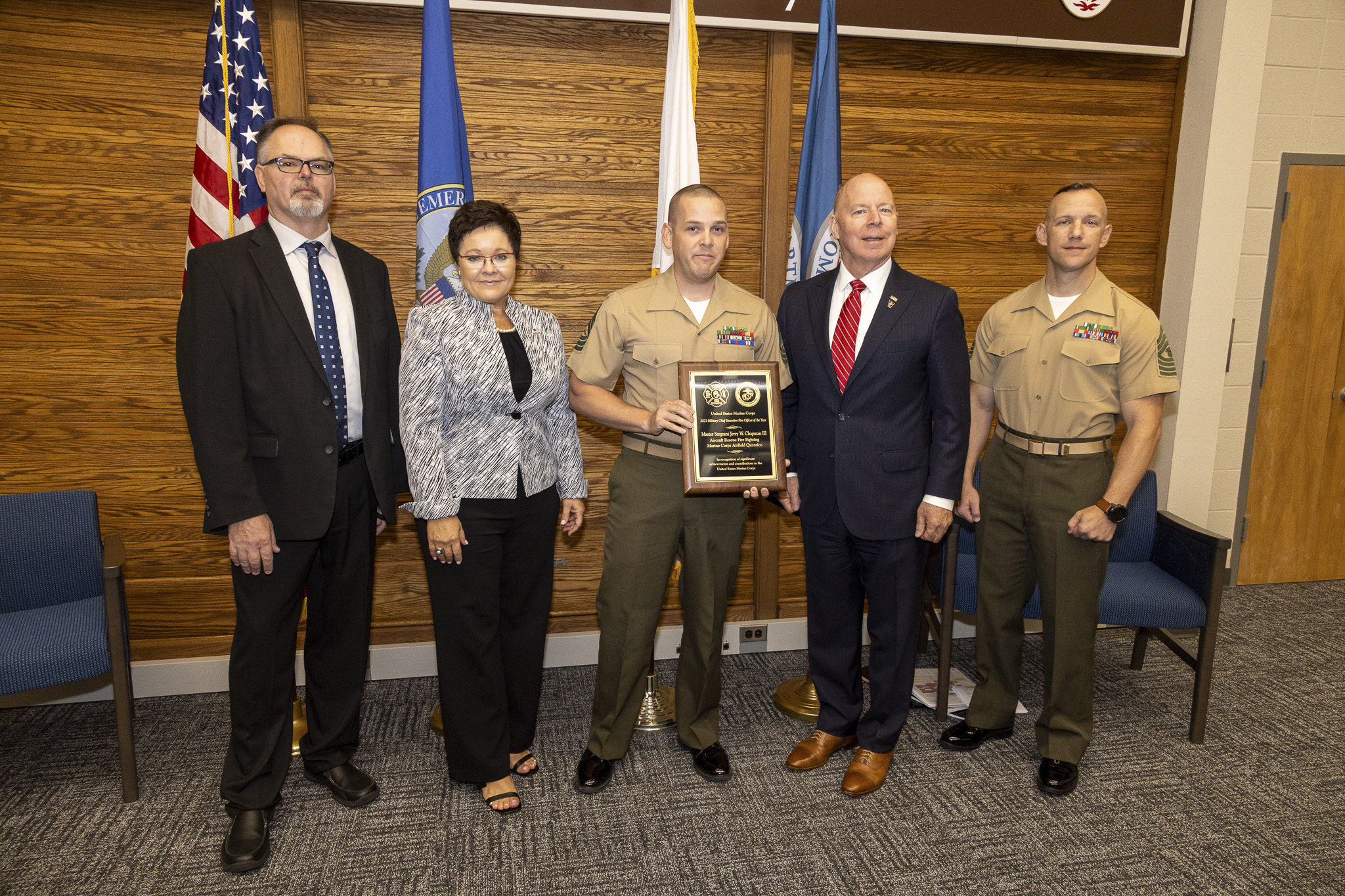 Master Sgt. Jerry Chapman, center, assigned to Marine Corps Airfield Quantico receives the 2023 Military Chief Executive Fire Officer of the Year award during the annual Marine Corps Fire & Emergency Services Awards Ceremony, June 12, 2024. The Marine Corps Fire & Emergency Services Annual Awards program recognizes combined Fire & Emergency Services (FES) and ARFF Department of the Year, EFR Department of the Year (Small, Medium, Large and EFR Categories), Fire Prevention Program of the Year, Military and Civilian Firefighter of the Year, Fire Officer of the Year, Fire Service Instructor of the Year, Executive Fire of the Year, and Emergency Medical Services Provider of the Year. (Photo by Mass Communication Specialist 1st Class Pedro A. Rodriguez)