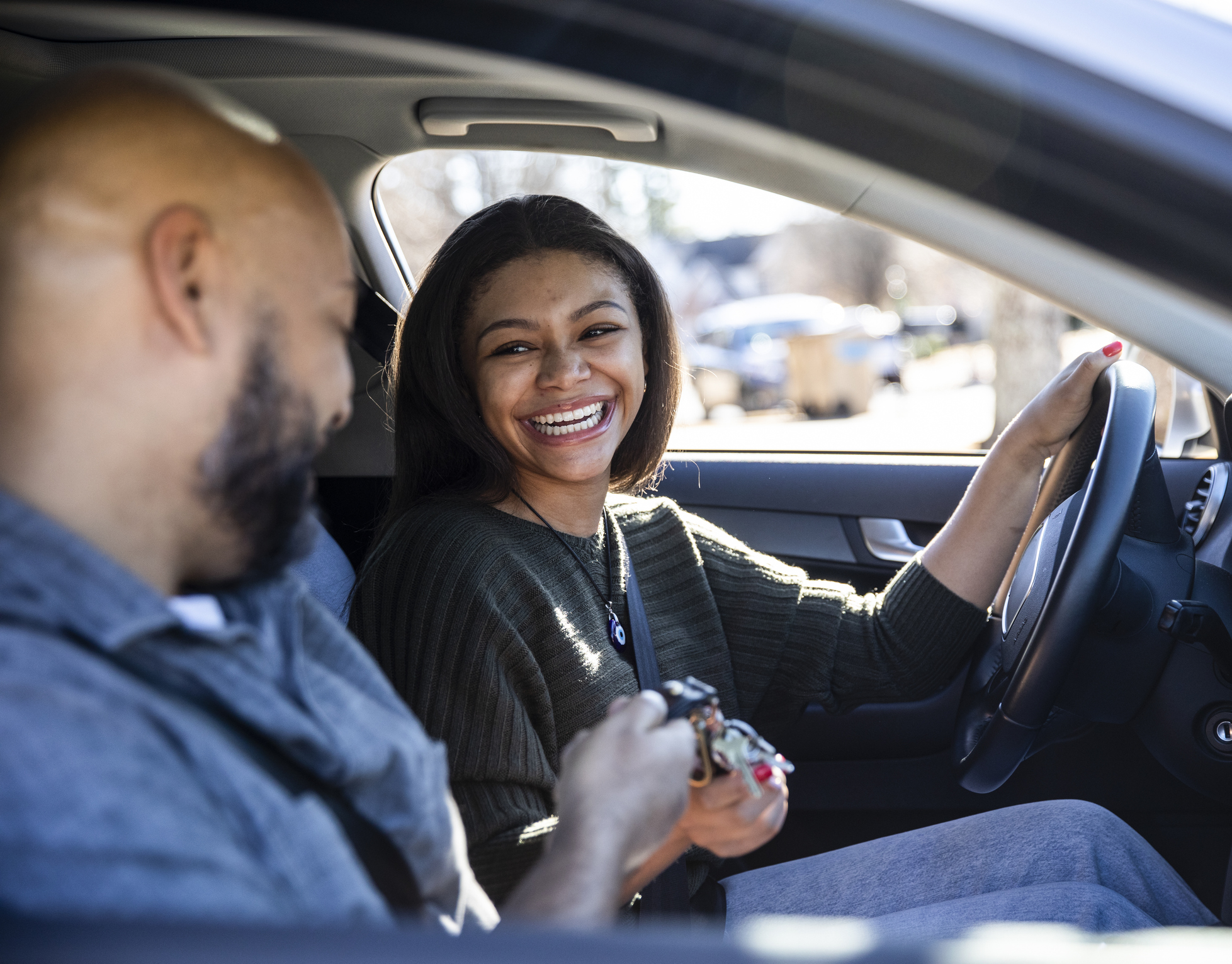 Father handing car keys to teenage daughter