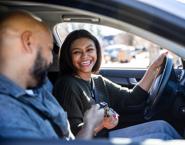 Father handing car keys to teenage daughter