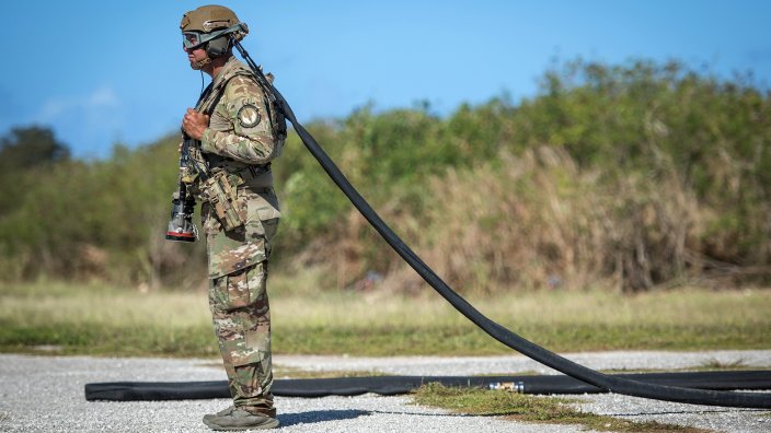 An Airman assigned to the 36th Mobility Response Squadron waits for the signal to hook up a helicopter expedient refuel system (HERS) to a C-130J Super Hercules, assigned to the 36th Airlift Squadron, during exercise COPE NORTH 2018 at Tinian, U.S. Commonwealth of the Northern Mariana Islands, Feb. 26. A HERS is a deployable fueling system capable of storing 3,000 gallons of fuel. (U.S. Air Force photo by Airman 1st Class Juan Torres Chardon)