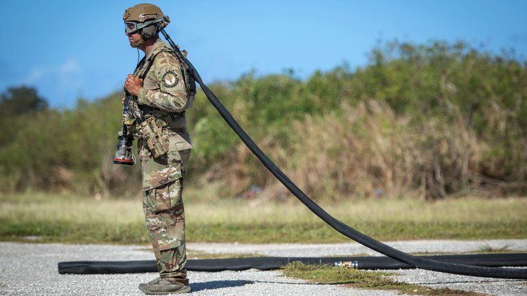 An Airman assigned to the 36th Mobility Response Squadron waits for the signal to hook up a helicopter expedient refuel system (HERS) to a C-130J Super Hercules, assigned to the 36th Airlift Squadron, during exercise COPE NORTH 2018 at Tinian, U.S. Commonwealth of the Northern Mariana Islands, Feb. 26. A HERS is a deployable fueling system capable of storing 3,000 gallons of fuel. (U.S. Air Force photo by Airman 1st Class Juan Torres Chardon)