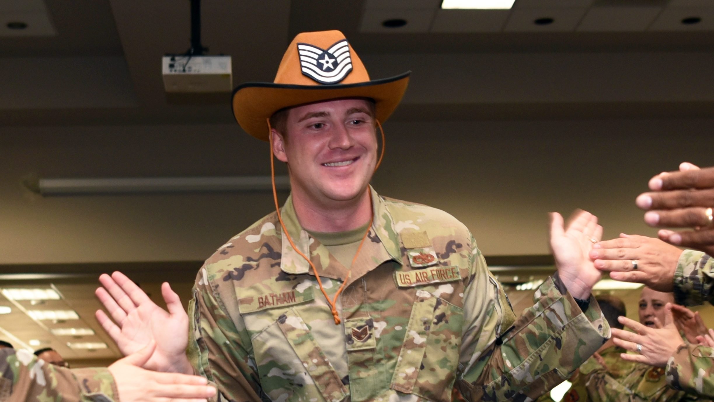 U.S. Air Force Staff Sgt. Eric Batham, 315th Training Squadron student, celebrates his achievement during the technical sergeant release party at the Event Center on Goodfellow Air Force Base, Texas, July 1, 2021. The Air Force-wide selection rate for technical sergeant was 26.94%. (U.S. Air Force photo by Senior Airman Abbey Rieves)