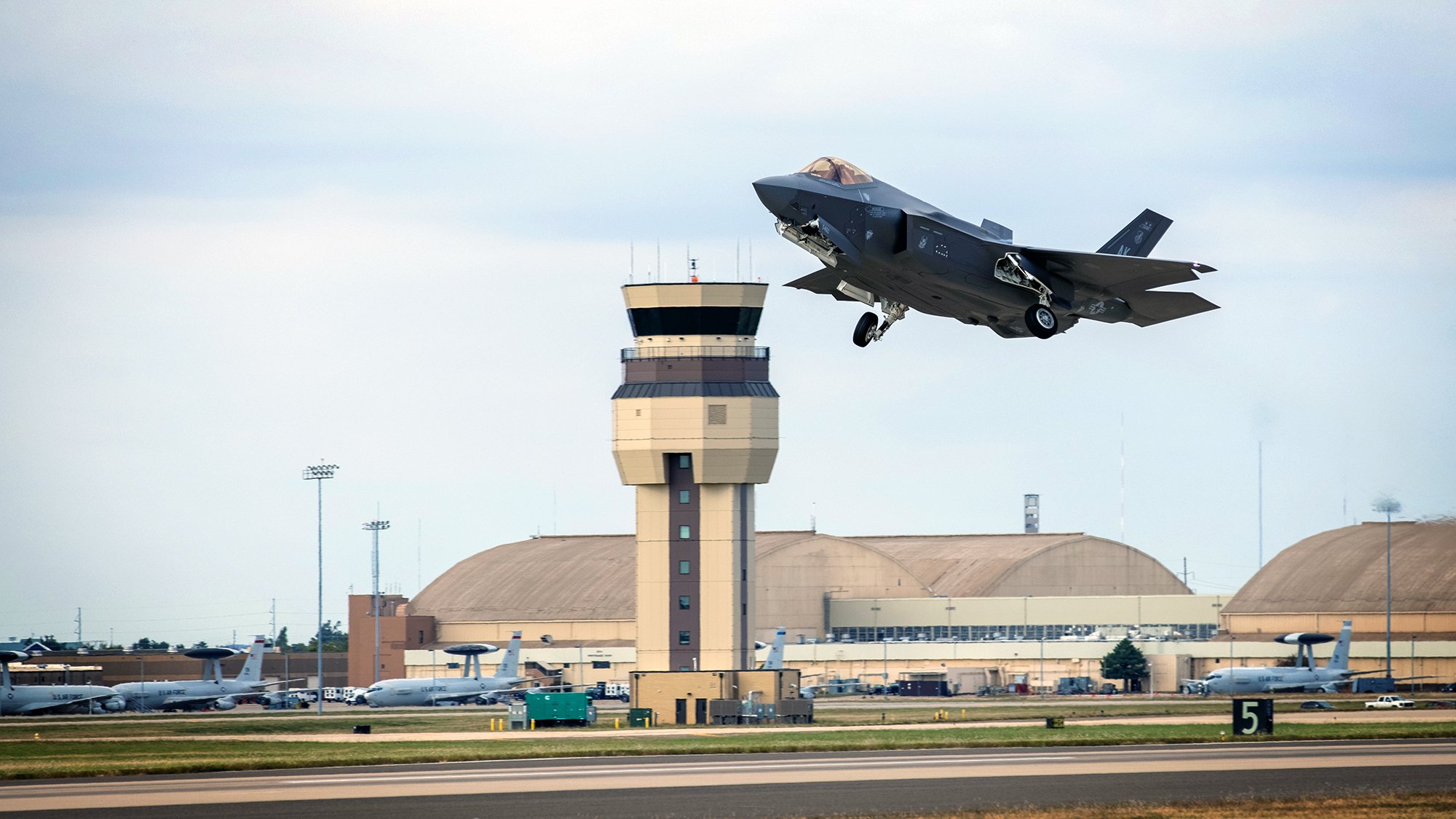 With the Tinker control tower in the background, an F-35 Lightning II aircraft takes off at Tinker Air Force Base, Oklahoma, Oct. 22, 2021. The Oklahoma City Air Logistics Complex's Heavy Maintenance Center performs all aspects of engine maintenance on the F135 engine, including all variants and for all partner nations. (U.S. Air Force photo by Paul Shirk)