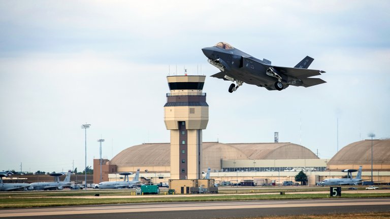 With the Tinker control tower in the background, an F-35 Lightning II aircraft takes off at Tinker Air Force Base, Oklahoma, Oct. 22, 2021. The Oklahoma City Air Logistics Complex's Heavy Maintenance Center performs all aspects of engine maintenance on the F135 engine, including all variants and for all partner nations. (U.S. Air Force photo by Paul Shirk)