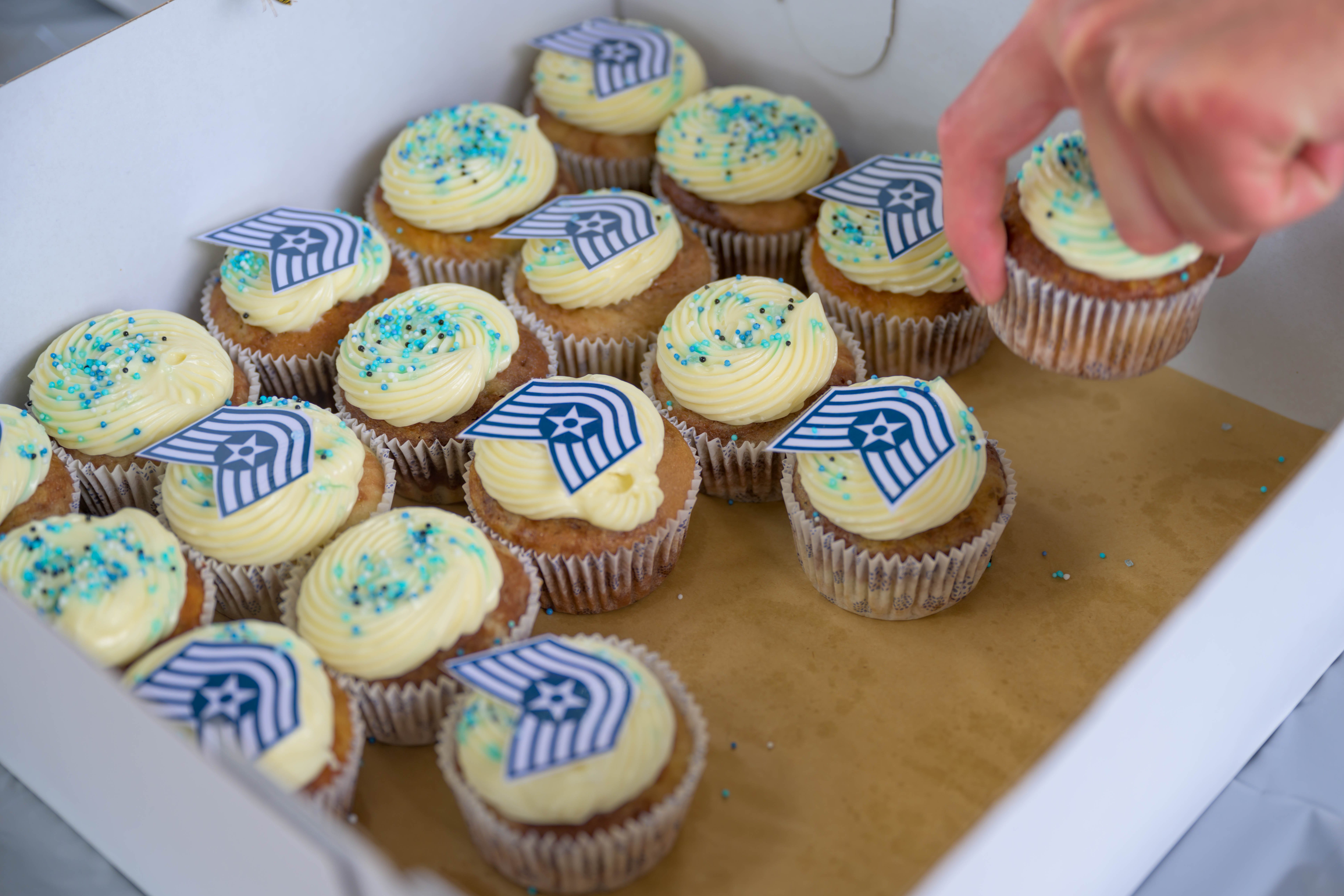 An attendee takes a complimentary decorated cupcake at a technical sergeant release event at Spangdahlem Air Base, Germany, July 9, 2025. Refreshments, snacks, and treats were offered to those in attendance, celebrating the hard work and success of over 50 staff sergeants who will be promoted. (U.S. Air Force photo by Airman 1st Class Gretchen McCarty)
