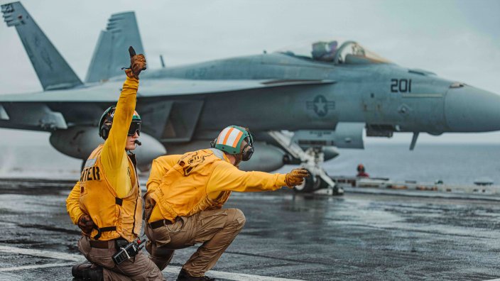 Lt. Ryan Vandrey, left, from Texas and Lt. Pirkle Jameson, right, from Wisconsin, shoot an F/A-18E Super Hornet, attached to Strike Fighter Squadron (VFA) 27, on the flight deck of Nimitz-class aircraft carrier USS George Washington (CVN 73) as part of Valiant Shield 2026 while underway in the Philippine Sea, June 22, 2026. Valiant Shield is a biennial, multilateral field training exercise conducted by the U.S. Armed Forces and partner nations in the Western Pacific focusing on joint, cross-combatant integration operating seamlessly across sea, air, land, and cyberspace. Exercises like Valiant Shield allow U.S. Pacific Command the opportunity to integrate forces from all branches of service and with our allies to conduct precise, lethal, and overwhelming multi-domain effects that demonstrate the strength and versatility of the Joint Force and our commitment to a free and open Indo-Pacific. (U.S. Navy photo by Mass Communication Specialist 3rd Class Nicolas Quezada) 