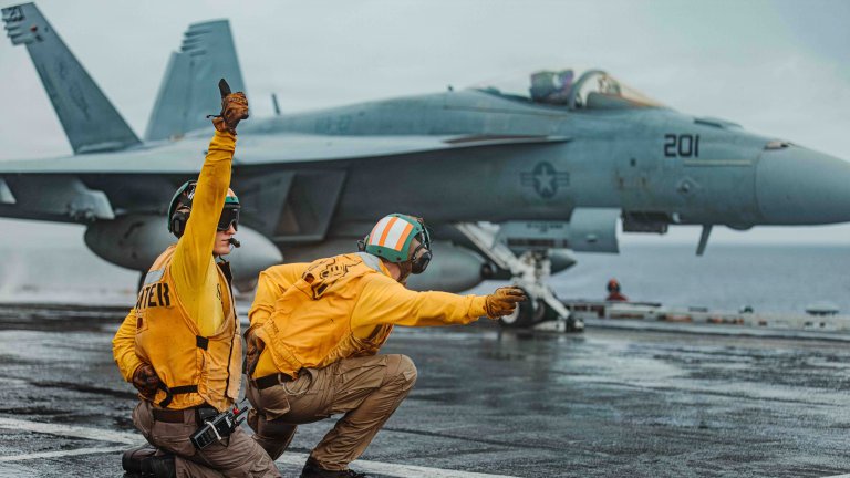 Lt. Ryan Vandrey, left, from Texas and Lt. Pirkle Jameson, right, from Wisconsin, shoot an F/A-18E Super Hornet, attached to Strike Fighter Squadron (VFA) 27, on the flight deck of Nimitz-class aircraft carrier USS George Washington (CVN 73) as part of Valiant Shield 2026 while underway in the Philippine Sea, June 22, 2026. Valiant Shield is a biennial, multilateral field training exercise conducted by the U.S. Armed Forces and partner nations in the Western Pacific focusing on joint, cross-combatant integration operating seamlessly across sea, air, land, and cyberspace. Exercises like Valiant Shield allow U.S. Pacific Command the opportunity to integrate forces from all branches of service and with our allies to conduct precise, lethal, and overwhelming multi-domain effects that demonstrate the strength and versatility of the Joint Force and our commitment to a free and open Indo-Pacific. (U.S. Navy photo by Mass Communication Specialist 3rd Class Nicolas Quezada) 