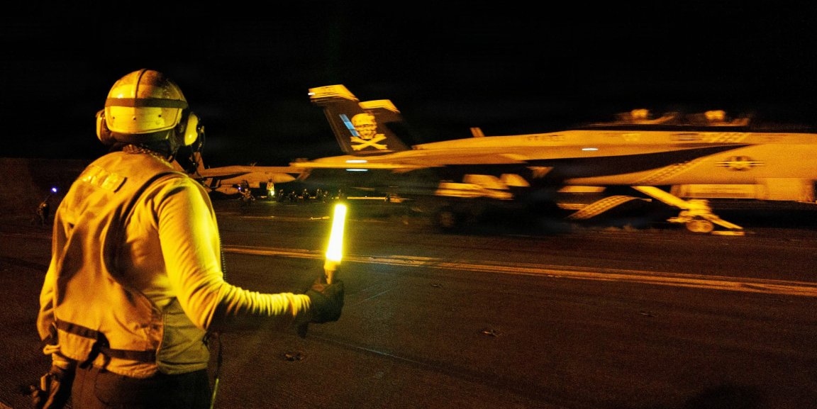 A U.S. Sailor signals an F/A-18E Super Hornet, attached to Strike Fighter Squadron (VFA) 103, on the flight deck of Nimitz-class aircraft carrier USS George H.W. Bush (CVN 77) while sailing in the Arabian Sea, June 23, 2026. USS George H.W. Bush is deployed to the U.S. 5th Fleet area of operations to support maritime security and stability in the Middle East. (U.S. Navy photo) 
