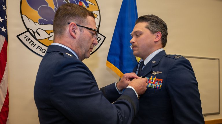 U.S. Air Force U.S. Air Force Lt. Gen. Robert Davis, commander, Alaskan North American Aerospace Defense Command Region, Alaskan Command ,and Eleventh Air Force, pins the Distinguished Flying Cross on Capt. Nathanial Welch, 18th Fighter Interceptor Squadron pilot and chief of plans and programs, during a ceremony at Eielson Air Force Base, Alaska, July 1, 2026. Welch received the decoration for his heroism and bravery he exemplified while evading enemy missiles flying as an F-16 Fighting Falcon pilot with the 480th Expeditionary Fighter Squadron at Prince Sultan Air Base, Kingdom of Saudi Arabia, evading enemy missiles through exceptional flying and protecting coalition aircraft until they were safely clear of the threat. (U.S. Air Force Photo by Airman 1st Class Mary Murray) 
