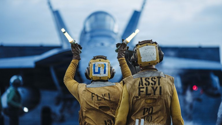 A U.S. Sailor signals an F/A-18 Super Hornet attached to Strike Fighter Squadron (VFA) 102 on the flight deck of Nimitz-class aircraft carrier USS George Washington (CVN 73), Sept. 26, 2026. George Washington is deployed to the U.S. 5th Fleet area of operations to support maritime security and stability in the Middle East. (U.S. Navy photo)