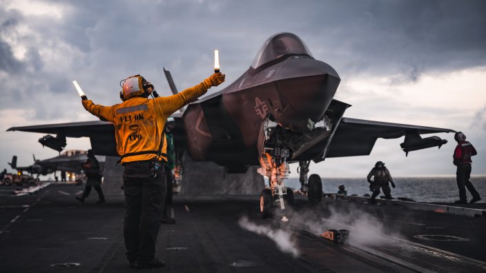 A U.S. Sailor signals an F-35C Lightning II assigned to Strike Fighter Squadron (VFA) 147 as it takes off from the flight deck of Nimitz-class aircraft carrier USS George Washington (CVN 73), Oct. 7, 2026. George Washington is deployed to the U.S. 5th Fleet area of operations to support maritime security and stability in the Middle East. (U.S. Navy photo)