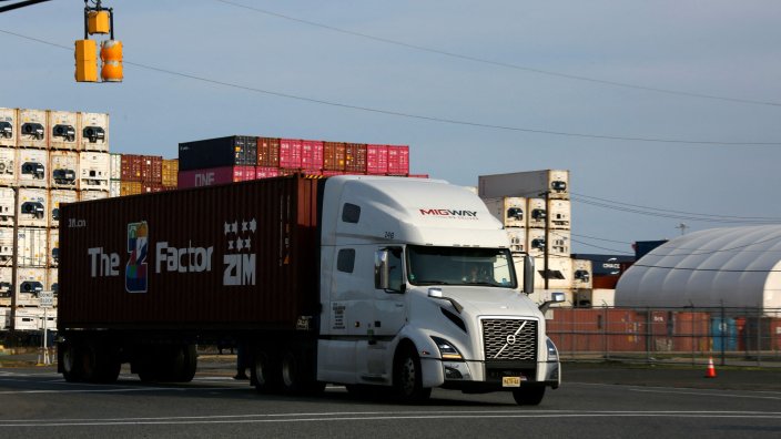 Image: Trucks exit from Port Newark Container Terminal in Newark, New Jersey on July 24, 2026. US President Donald Trump slapped sweeping new tariffs on 60 trading partners and saw 25-percent duties take effect on Brazilian products. Both cases involved an authority that has previously been used to impose levies. (Photo by Kena Betancur / AFP via Getty Images) 