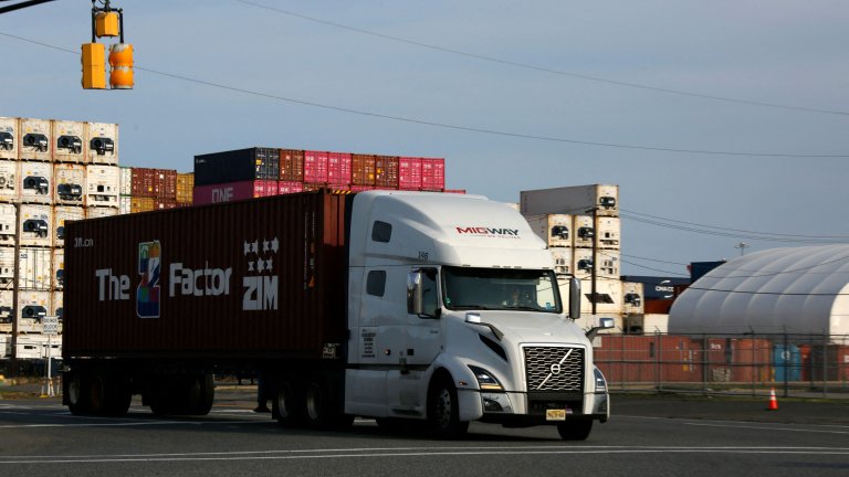 Image: Trucks exit from Port Newark Container Terminal in Newark, New Jersey on July 24, 2026. US President Donald Trump slapped sweeping new tariffs on 60 trading partners and saw 25-percent duties take effect on Brazilian products. Both cases involved an authority that has previously been used to impose levies. (Photo by Kena Betancur / AFP via Getty Images) 
