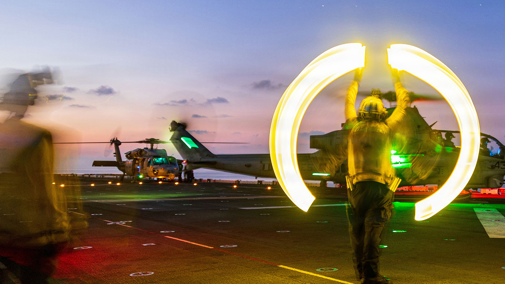 A U.S. Sailor assigned to Wasp-class amphibious assault ship USS Boxer (LHD 4) signals an AH-1Z Viper assigned to Marine Medium Tiltrotor Squadron (VMM) 163 (Reinforced), 11th Marine Expeditionary Unit, to take-off during flight operations in the South China Sea, June 13, 2026. The 11th MEU, embarked aboard the Boxer Amphibious Ready Group, is a persistent, combat credible force contributing to deterrence and crisis response in the U.S. 7th Fleet area of operations. U.S. 7th Fleet, the U.S. Navy's largest forward-deployed numbered fleet, routinely interacts and operates with allies and partners to preserve a free and open Indo-Pacific. (U.S. Marine Corps photo by Lance Cpl. Nicole Stuart)