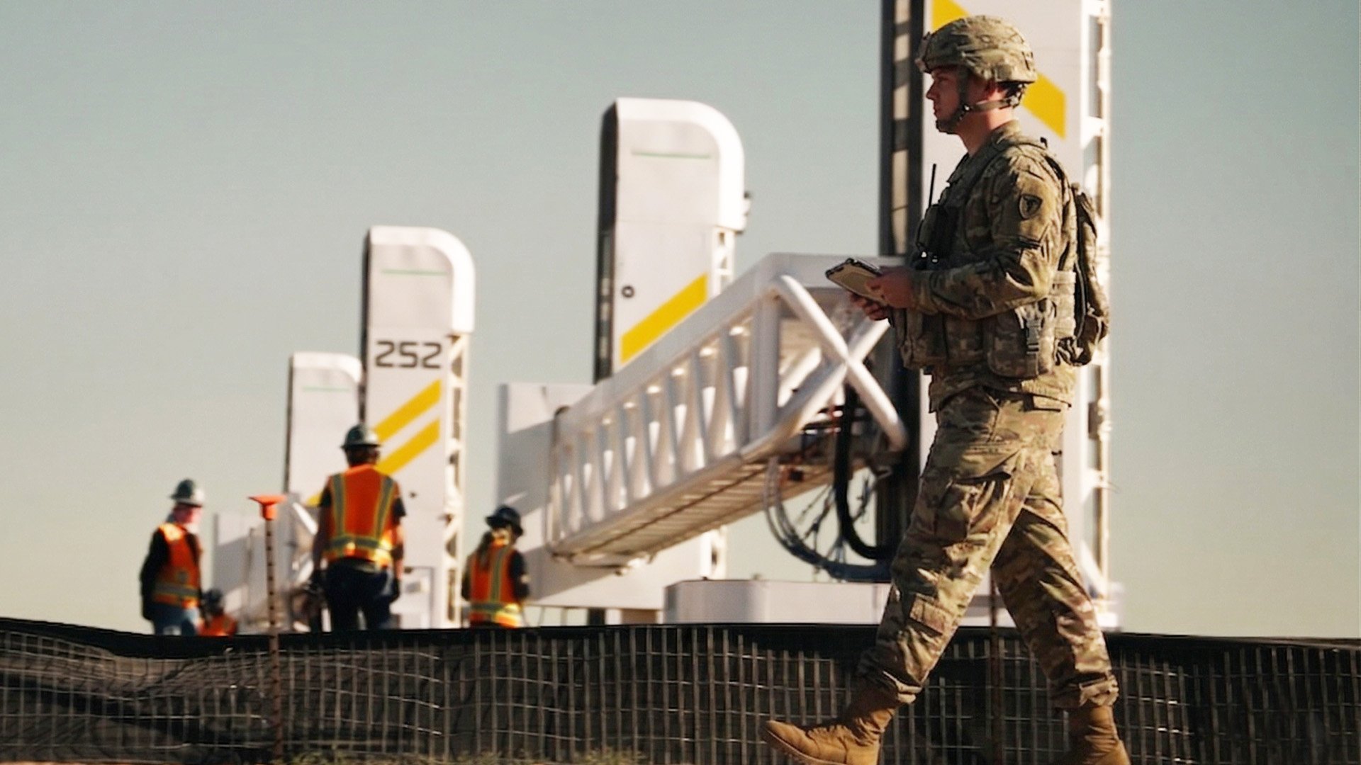 A soldier oversees the massive 3-D printers at Fort Bliss, Texas, as they construct new barracks for troops deployed to the U.S.-Mexico border. The barracks opened in late July with beds for 560.