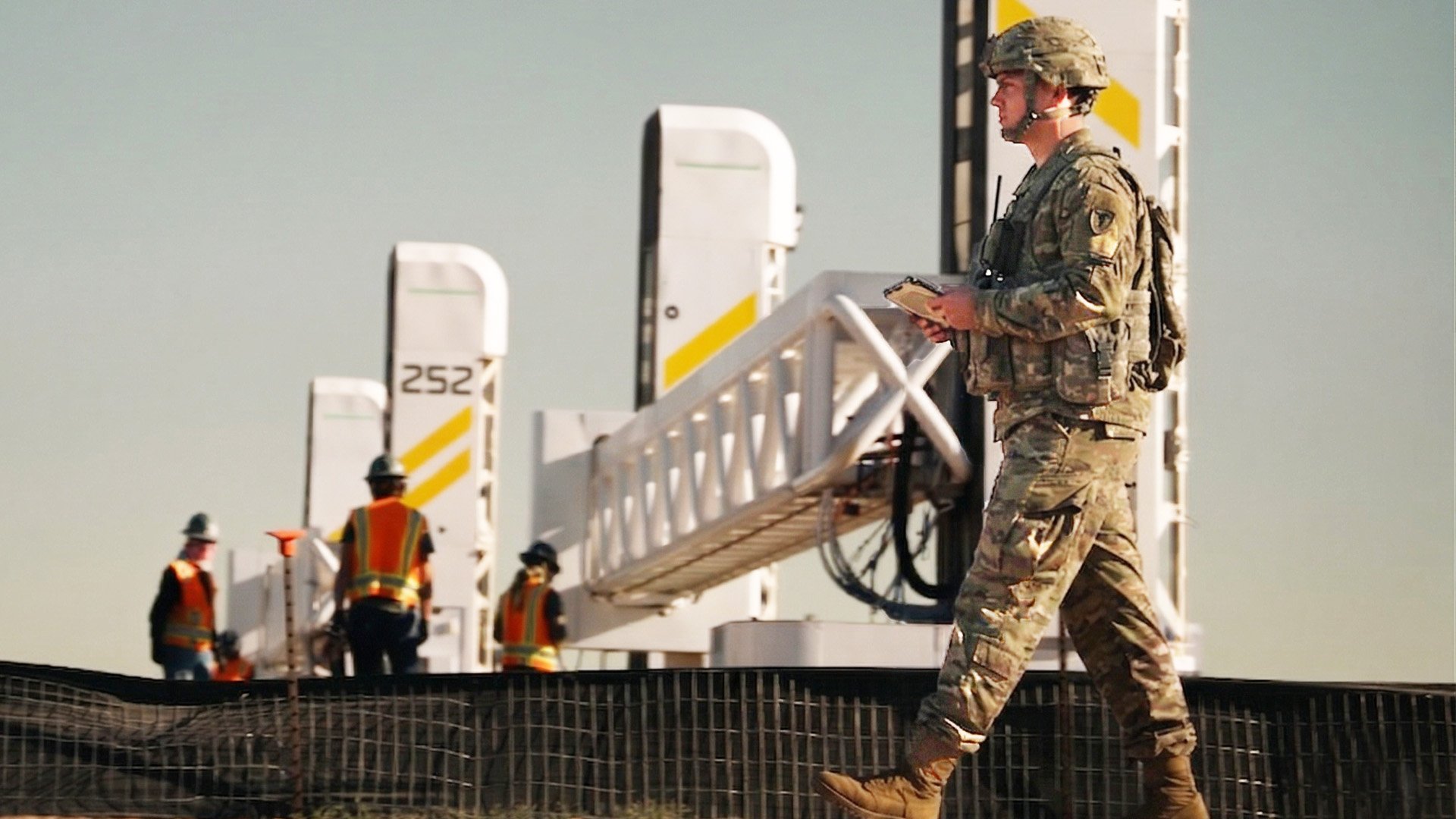 A soldier oversees the massive 3-D printers at Fort Bliss, Texas, as they construct new barracks for troops deployed to the U.S.-Mexico border. The barracks opened in late July with beds for 560.