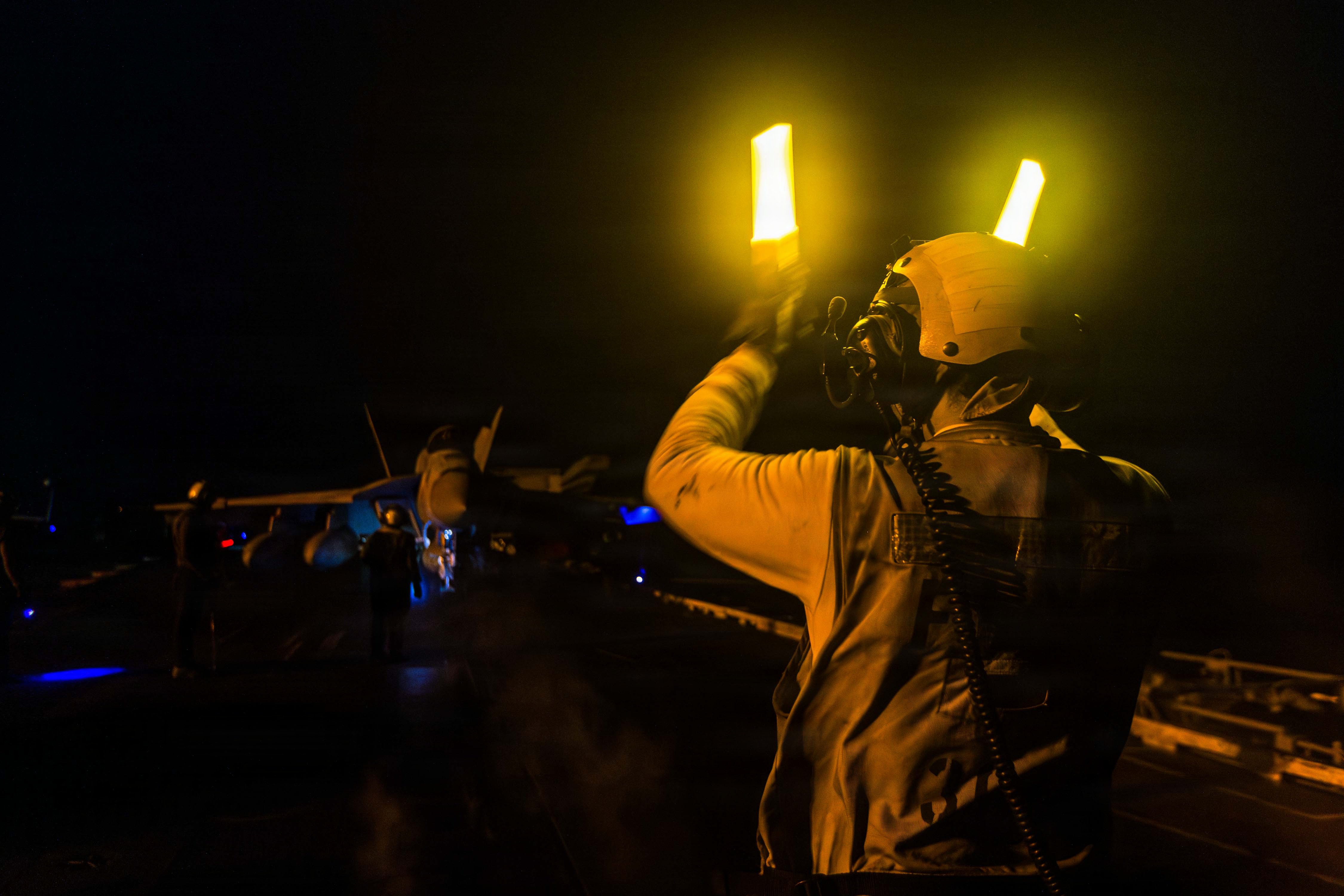 A U.S. Sailor taxis an F/A-18E Super Hornet, attached to Strike Fighter Squadron (VFA) 151, on the flight deck of Nimitz-class aircraft carrier USS Abraham Lincoln (CVN 72) during Operation Epic Fury, March. 28, 2026. (U.S. Navy photo)