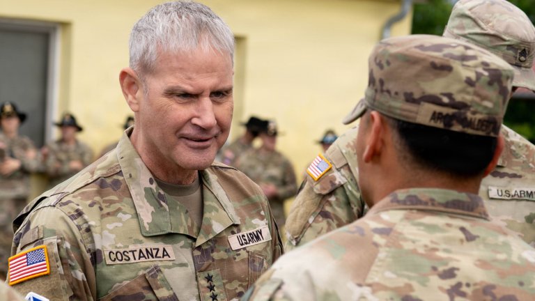 Image: U.S. Army Staff Sgt. Jesus Arce Calderon, assigned to 12th Combat Aviation Brigade, receives a coin from Lt. Gen. Charles Costanza, commanding general of V Corps, during V Corps’ Best Squad Competition awards ceremony at Grafenwöhr, Germany, June 11, 2026. Teams representing units from across V Corps will test their tactical proficiency, communication, and overall cohesion as they compete for the title of Best Squad. Winners of this competition will advance to compete at the U.S. Army Europe and Africa Best Squad Competition. (U.S. Army Photo by Cpl. Grant Hockley) 