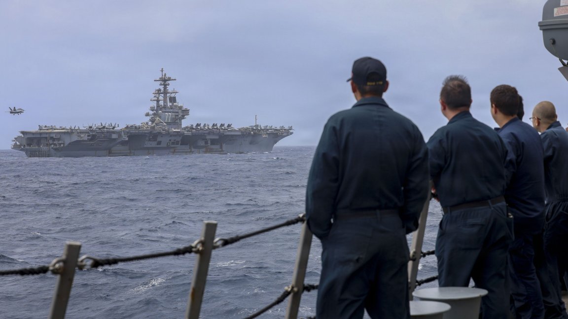 U.S Sailors, assigned to Arleigh Burke-class guided-missile destroyer USS Delbert D. Black (DDG 119), observe an F/A-18F Super Hornet, attached to Strike Fighter Squadron (VFA) 103, preparing to land on the flight deck of Nimitz-class aircraft carrier USS George H.W. Bush (CVN 77), June 29, 2026. Delbert D. Black is deployed to the U.S. 5th Fleet area of operations to support maritime security and stability in the Middle East. (U.S. Navy photo) 