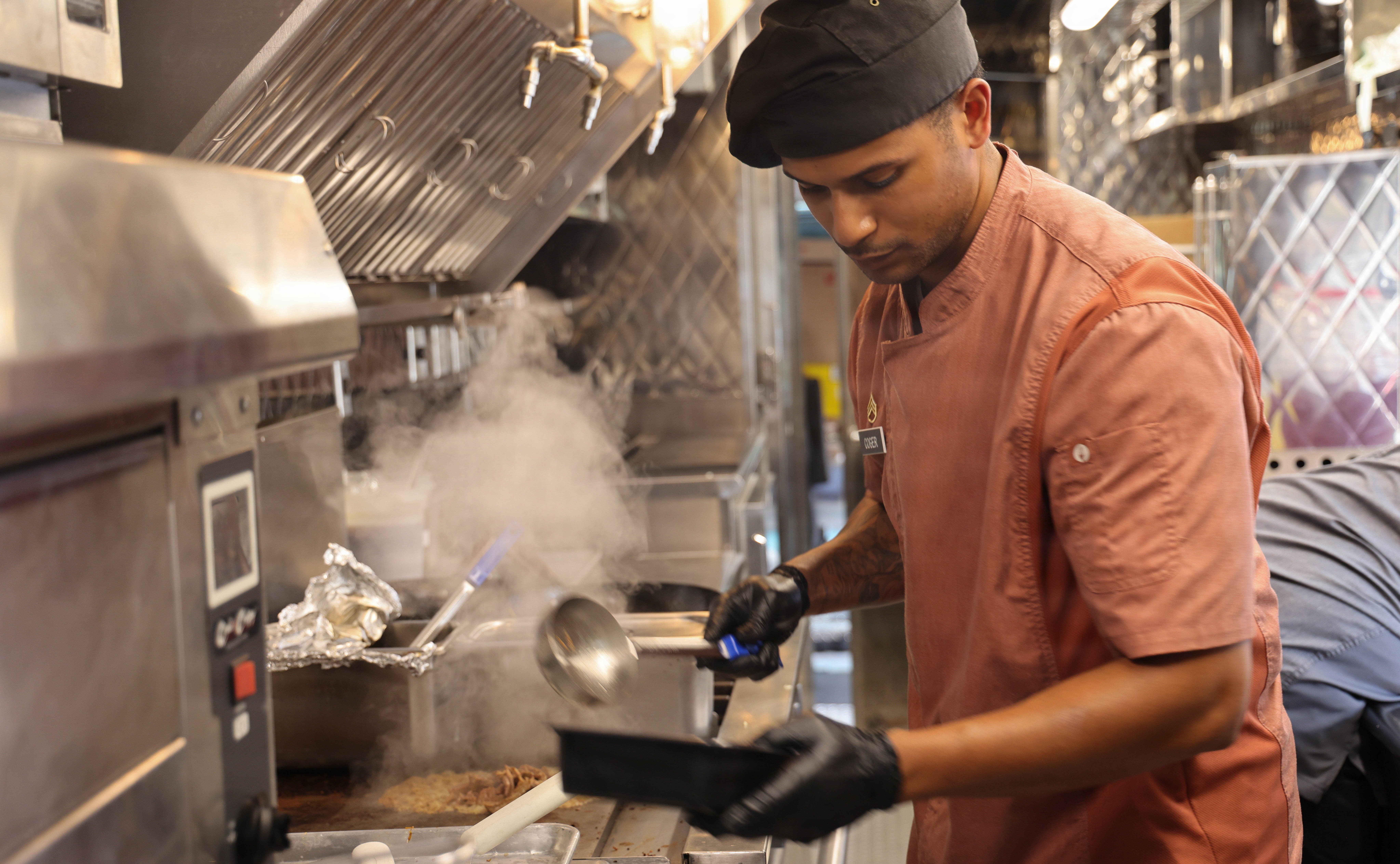 U.S. Army culinary noncommissioned officer prepares a fresh meal at The Outpost food truck at Fort Shafter, Hawaii, Aug. 6, 2026. The Outpost provides Soldiers with convenient, affordable and nutritious meal options every Tuesday and Thursday from 11 a.m. to 2 p.m. as part of a 90-day pilot program supporting Soldier readiness through improved access to healthy food. (U.S. Army photo by Staff Sgt. Egypt Johnson)