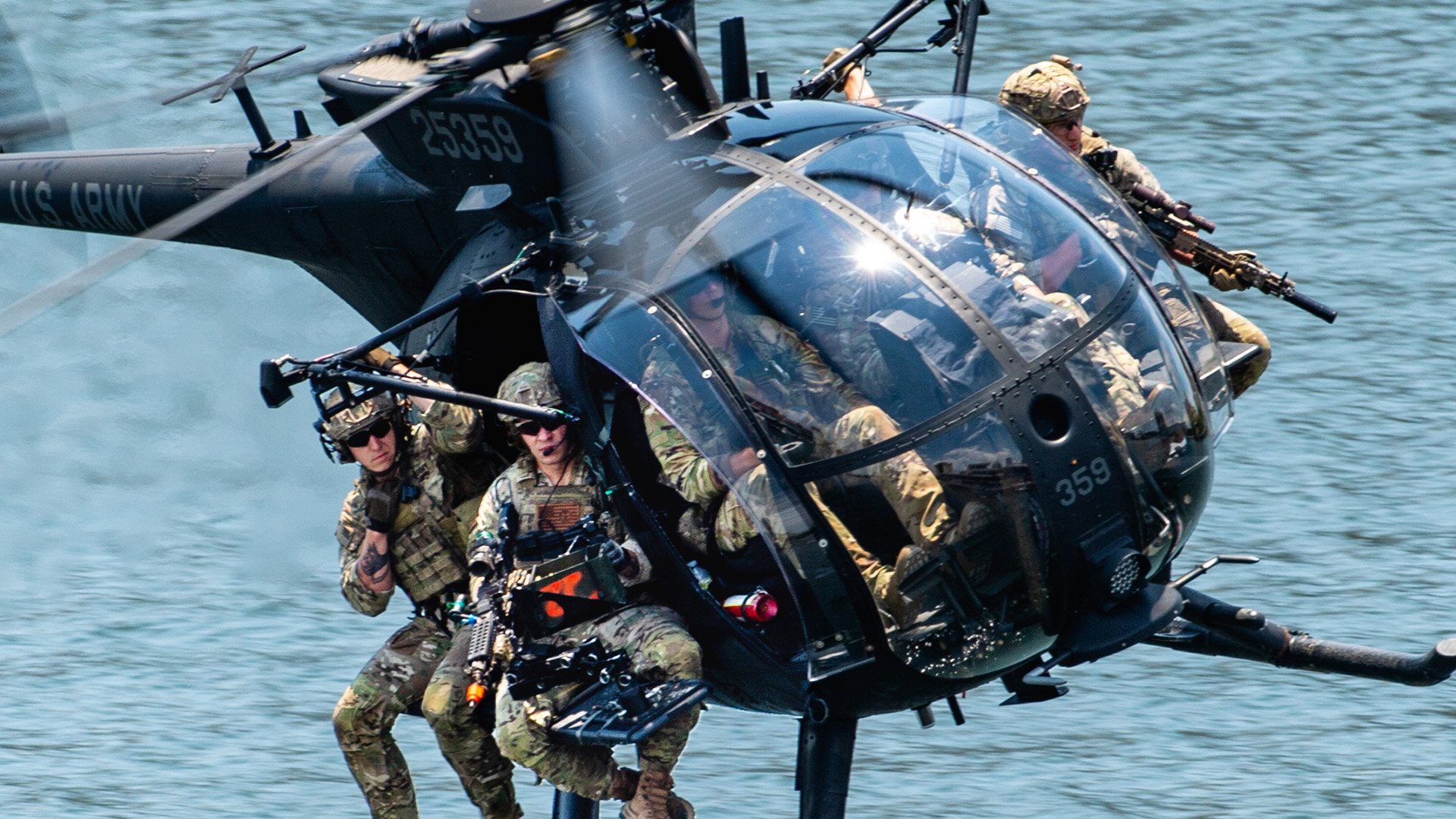 U.S. Special Operations Forces members fly over Tampa Bay in a U.S. Army MH-6 helicopter during a SOF capabilities demonstration May 18, 2022 in Tampa, Florida. SOF Week is the premier gathering for the SOF community and industry, bringing together more than 11,000 attendees, including representatives from more than 100 countries to collaborate on new initiatives and capabilities needed for SOF professionals to compete and win in the future. (U.S. Air Force photo by Staff Sgt. Alexander Cook)