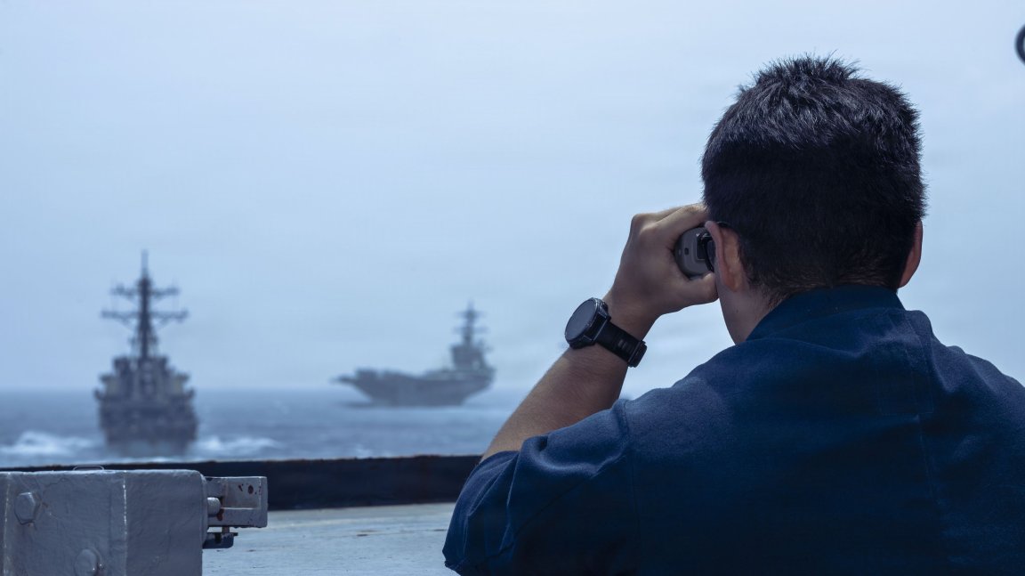 A U.S. Sailors use a laser range finder to check distances of other vessels from the bridgewing Arleigh Burke-class guided-missile destroyer USS Milius (DDG 69) during a photo exercise in the Arabian Sea, June 30, 2026. Milius is deployed to the U.S. 5th Fleet area of operation to support maritime security and stability in the Middle East. (U.S. Navy photo) 