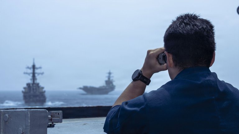 A U.S. Sailors use a laser range finder to check distances of other vessels from the bridgewing Arleigh Burke-class guided-missile destroyer USS Milius (DDG 69) during a photo exercise in the Arabian Sea, June 30, 2026. Milius is deployed to the U.S. 5th Fleet area of operation to support maritime security and stability in the Middle East. (U.S. Navy photo) 