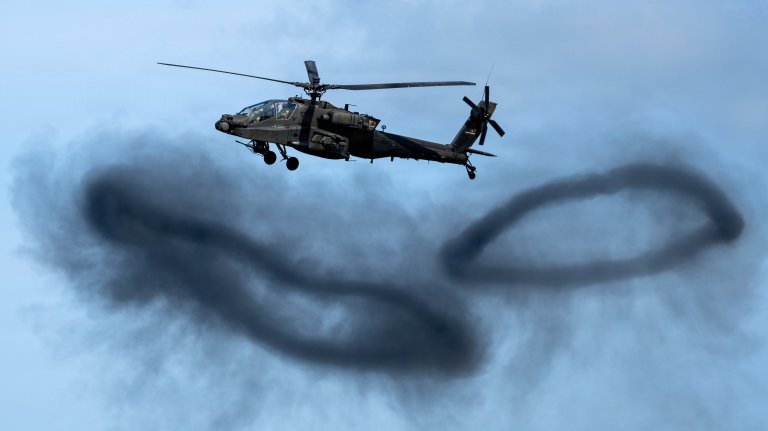 A U.S. Army AH-64E Apache Guardian aircraft assigned to the 1st Battalion, 25th Aviation Regiment, 11th Airborne Division, out of Fort Wainwright, Alaska, flies over explosions during the Joint Forces Demonstration for the Arctic Thunder Open House at Joint Base Elmendorf-Richardson, Alaska, Aug. 9, 2026. The AH-64E conducts armed reconnaissance, close combat, mobile strike, and vertical maneuver missions when required, in day, night, obscured battlefield and adverse weather conditions. (U.S. Air Force photo by 2nd Lt. Daniel Bellerive)