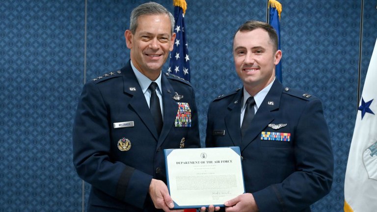 Air Force Chief of Staff Gen. Ken Wilsbach, left, presents an award citation to Capt. Michael Cloninger, right, F-22 Raptor pilot from the 90th Fighter Squadron, 3rd Operations Group, Joint Base Elmendorf-Richardson, Alaska, during a ceremony at the Pentagon, Sept. 8, 2026. Cloninger was presented with the 2025 Koren Kolligian, Jr. Trophy, which recognizes outstanding feats of airmanship by aircrew members who by extraordinary skill, exceptional alertness, ingenuity, or proficiency, averted accidents or minimized the seriousness of the accidents in terms of injury, loss of life, aircraft damage, or property damage. (U.S. Air Force photo by Chad Trujillo) 
