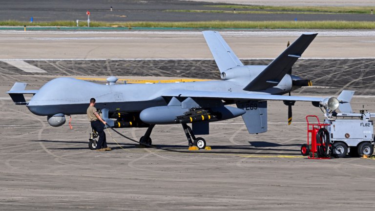 A US Air Force personnel prepares an MQ-9 Reaper drone for a mission on the tarmac at Rafael Hernandez Airport in Aguadilla, Puerto Rico, on December 27, 2025. The United States has deployed a major military force in the Caribbean and has recently intercepted oil tankers as part of a naval blockade against Venezuelan vessels it considers to be under sanctions. Since September, US forces have launched dozens of air strikes on boats that Washington alleges, without showing evidence, were transporting drugs. More than 100 people have been killed. (Photo by Miguel J. Rodriguez Carrillo / AFP via Getty Images)