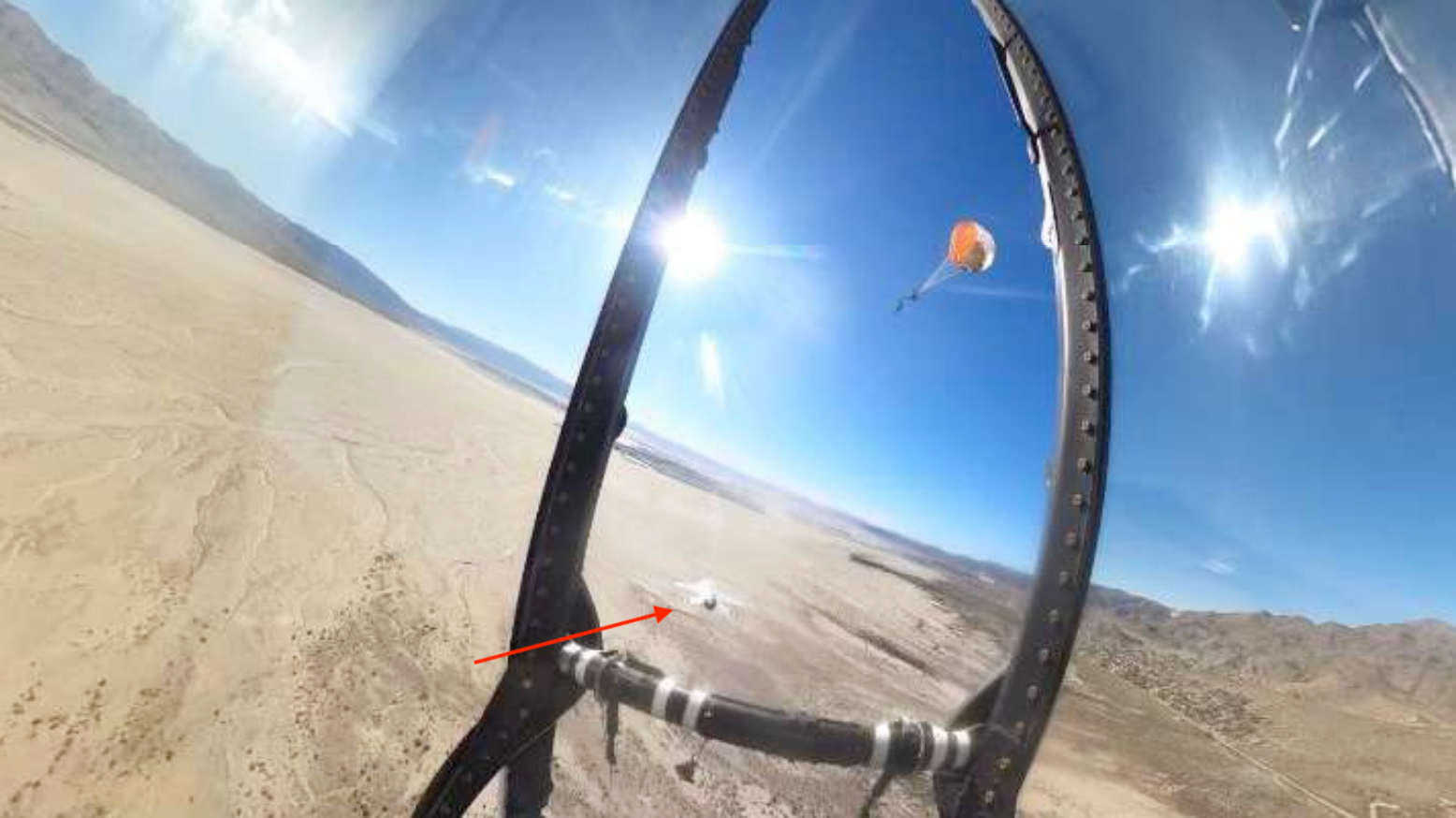 An image caputured by an in-cockpit camera of a Thunderbird pilot under a parachute after ejecting on Dec. 5, 2025. The F-16 can be seen continuing to fly beneath the pilot.