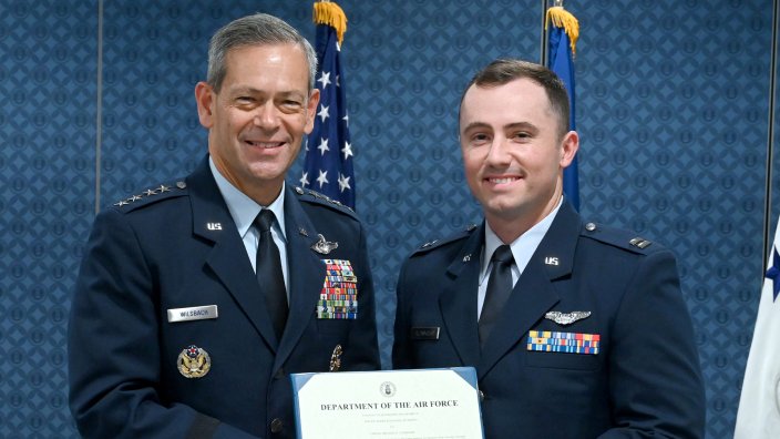 Air Force Chief of Staff Gen. Ken Wilsbach presents the 2025 Koren Kolligian Jr. Trophy to Capt. Michael Cloninger of the 90th Fighter Squadron, who "belly landed" his F-22 fighter jet after the plane's landing gear fell off.