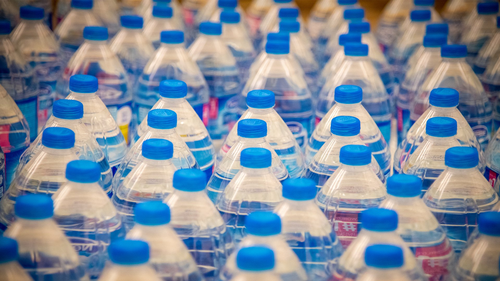 CAMP HUMPHREYS, Republic of Korea - Bottles of water are lined up to be placed in welcome bags for incoming single and unaccompanied Soldiers entering the quarantine process, during a Bag Brigade Drive at Freedom Chapel here, Nov. 21. Volunteers assembled bags including water, Korean snacks and treats, information packets and amenities to help ease the quarantine process for Soldiers as well as to show them that the community here supports and values them.