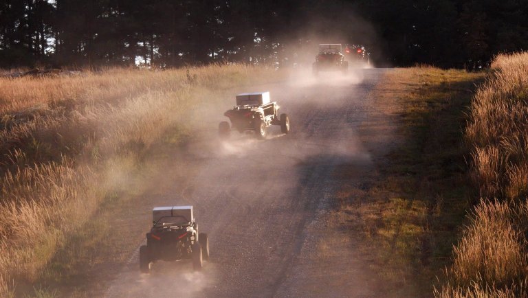 An operator supervises four autonomous ground vehicles as they carry sensing, kinetic, and non-kinetic payloads in a proof-of-concept experiment demonstrating multi-domain autonomous operations.