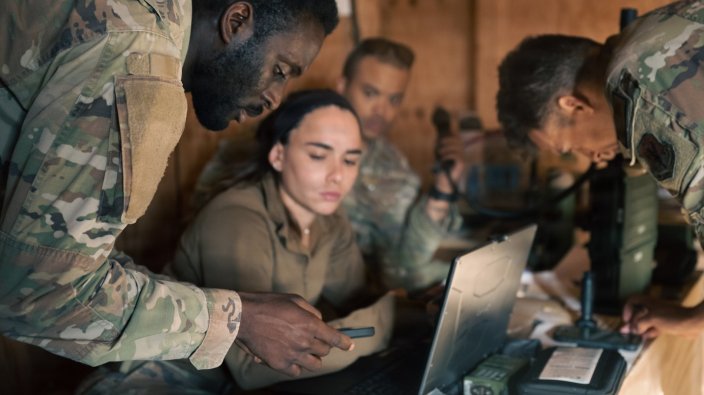 Defenders and communications specialists from the 205th Base Defense Squadron review laptops and mobile phones to gather communications data during an exercise at Fort Drum, New York, Aug. 25, 2026. 205th BDS defenders trained on a wartime security mission during Operation WIRE. (Air National Guard photo by Airman 1st Class Joshua Adamy) 