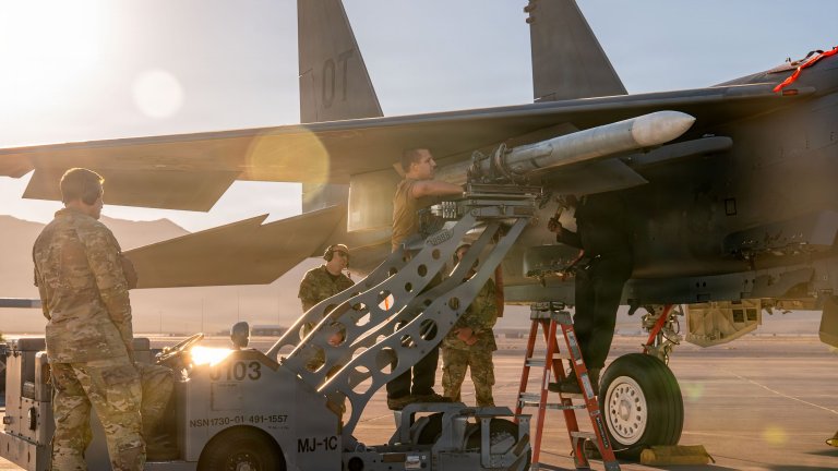 U.S. Airmen assigned to the 757th Aircraft Maintenance Squadron load an inert munition onto an F-15E Strike Eagle aircraft at Nellis Air Force Base, Nevada, Oct. 2, 2026. The Airmen competed in the 3rd Quarter Load Competition in which seven aircraft maintenance teams were assessed on their technical, mental, and physical proficiency. (U.S. Air Force photo by Airman 1st Class Heather Amador Paulino)