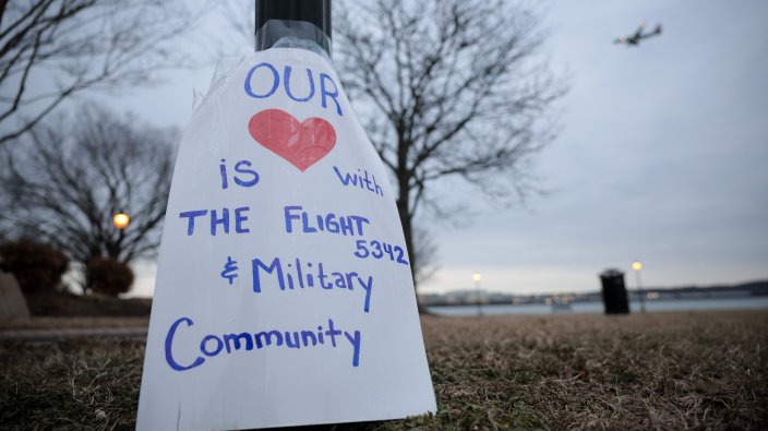 ALEXANDRIA, VIRGINIA - FEBRUARY 05: A sign is shown affixed to a lamp post at a candlelit vigil held for the flight crash victims at Rivergate City Park on February 05, 2025 in Alexandria, Virginia. An American Airlines flight from Wichita, Kansas collided midair with a military Black Hawk helicopter while on approach to Ronald Reagan Washington National Airport on January 29 outside of Washington, DC. All 67 people aboard both aircraft perished in the accident. (Photo by Kayla Bartkowski/Getty Images)