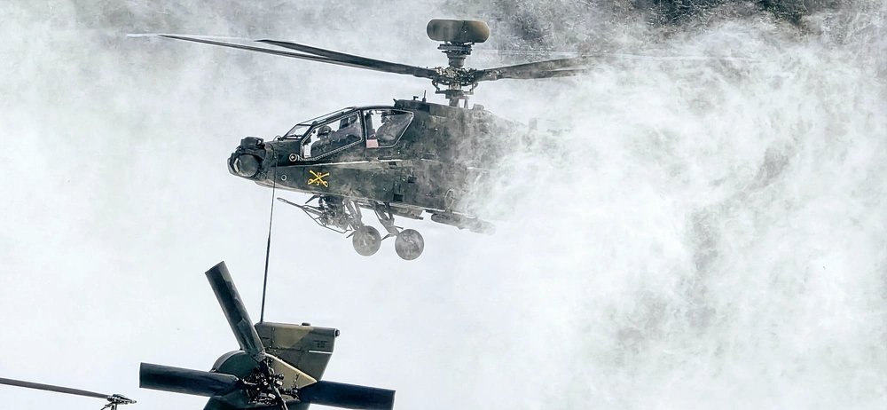 U.S. Army Chief Warrant Officer 2 Mitch Flowers and Chief Warrant Officer 2 Dustin Pettis, assigned to Alpha Company, 1-3 Attack Battalion, 3rd Combat Aviation Brigade, land their AH64E Apache on Sierra Checkpoint at Joint Multinational Readiness Center's Hohenfels Training Area, Germany, Feb. 18, 2026, to rearm and refuel. 7th Army Training Command provides a unique environment in Europe to develop leaders and formations who are prepared for large-scale combat operations.